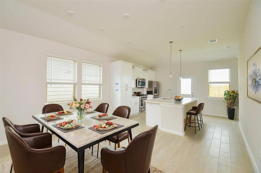 This open-concept area combines the living, dining, and kitchen spaces into one cohesive and inviting environment.