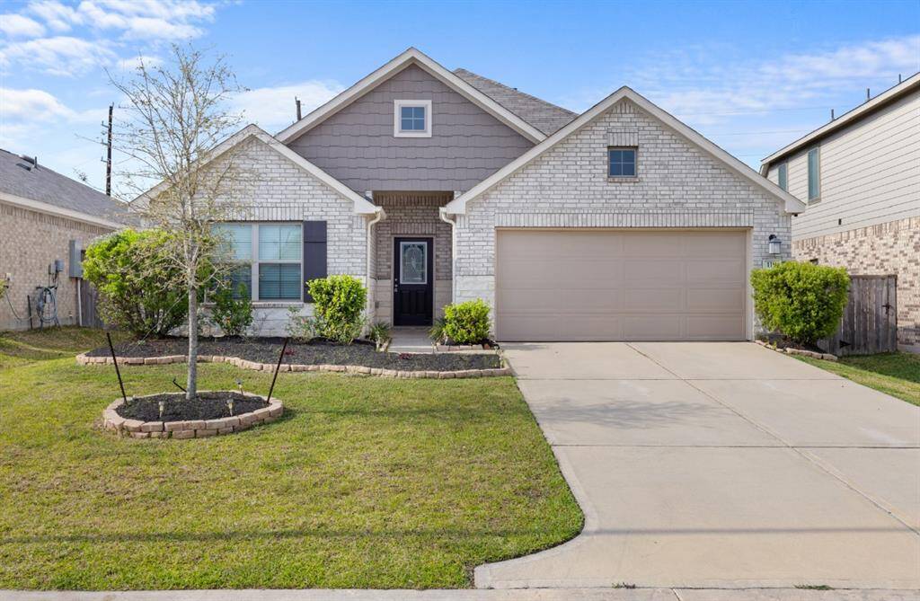 Exterior of home includes a combination of brick and stone, accented with window shutters