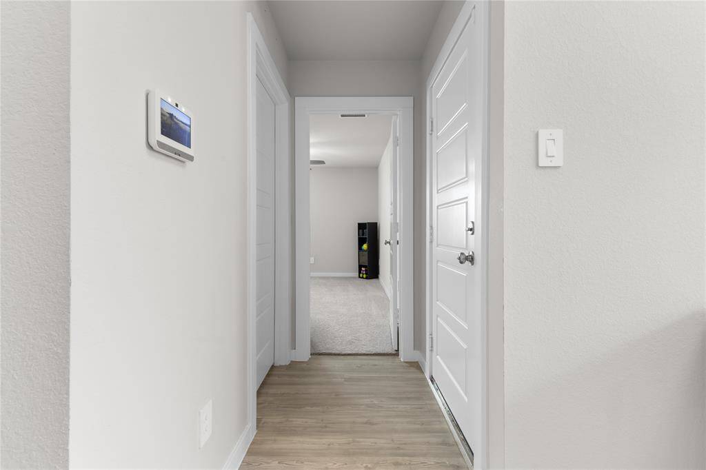 Off to the side, separate from other rooms, this hallway leads to laundry room (door to the left) and another bedroom straight ahead