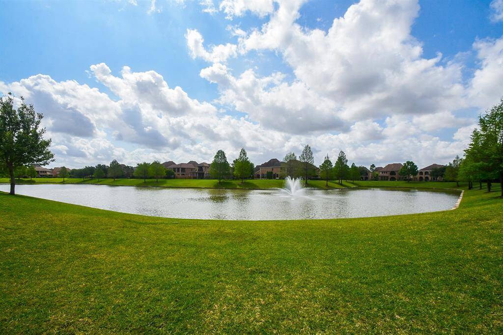 Walking distance to the picturesque lake with a fountain, surrounded by lush green lawns and trees