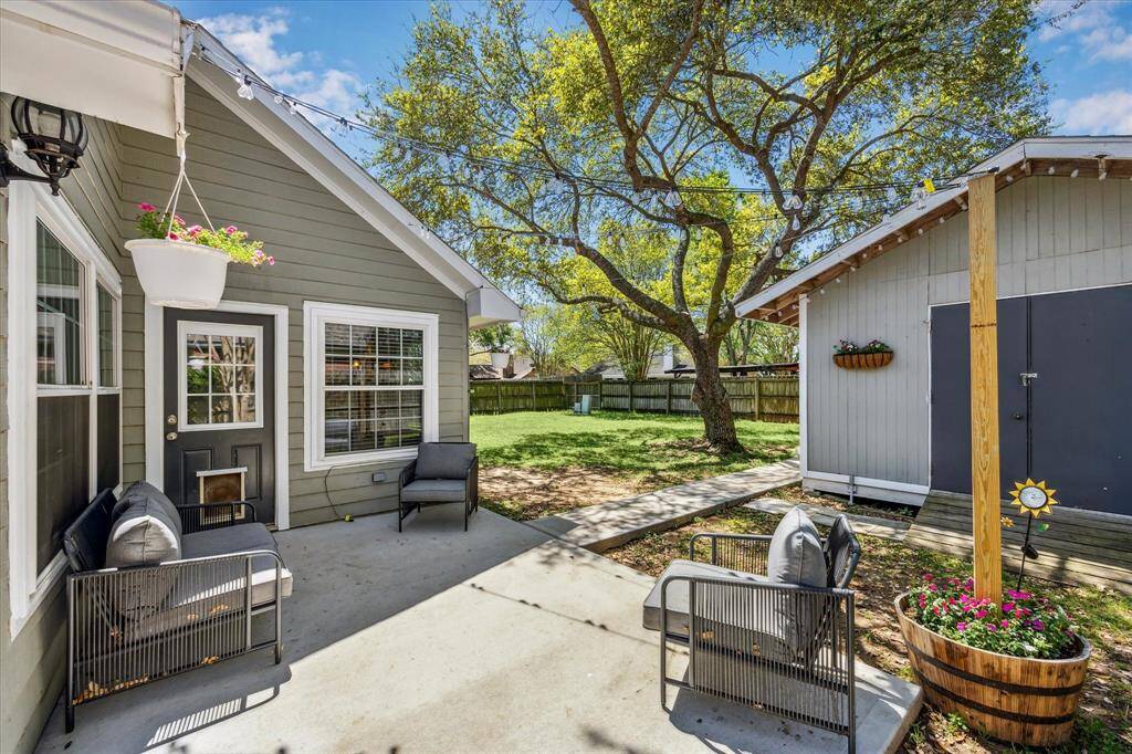 Back Patio leading to building with an additional room and storage in backyard
