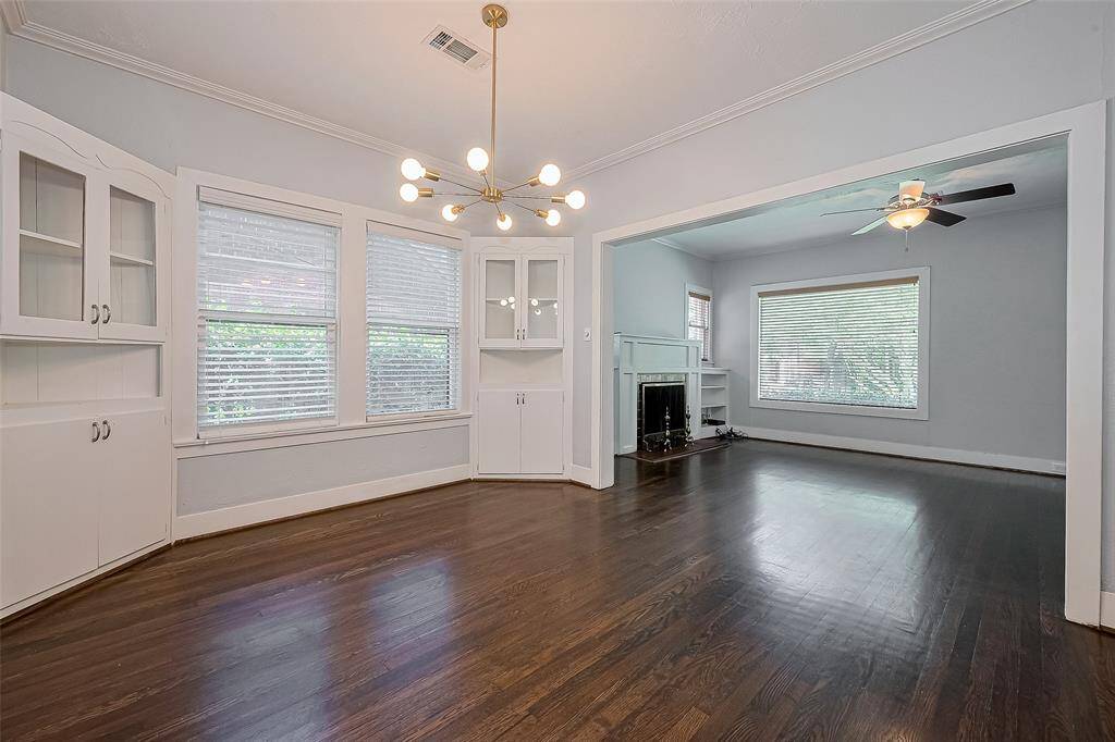 This entryway features a unique round-top door with a window, textured walls, and dark hardwood floors, creating a welcoming and stylish first impression.