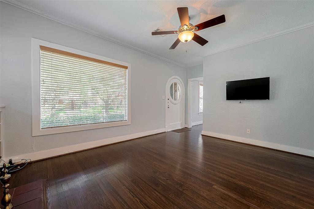 This room features hardwood floors, a ceiling fan, ample closet space, and an en-suite bathroom. Its neutral walls offer a versatile space ready for personalization.