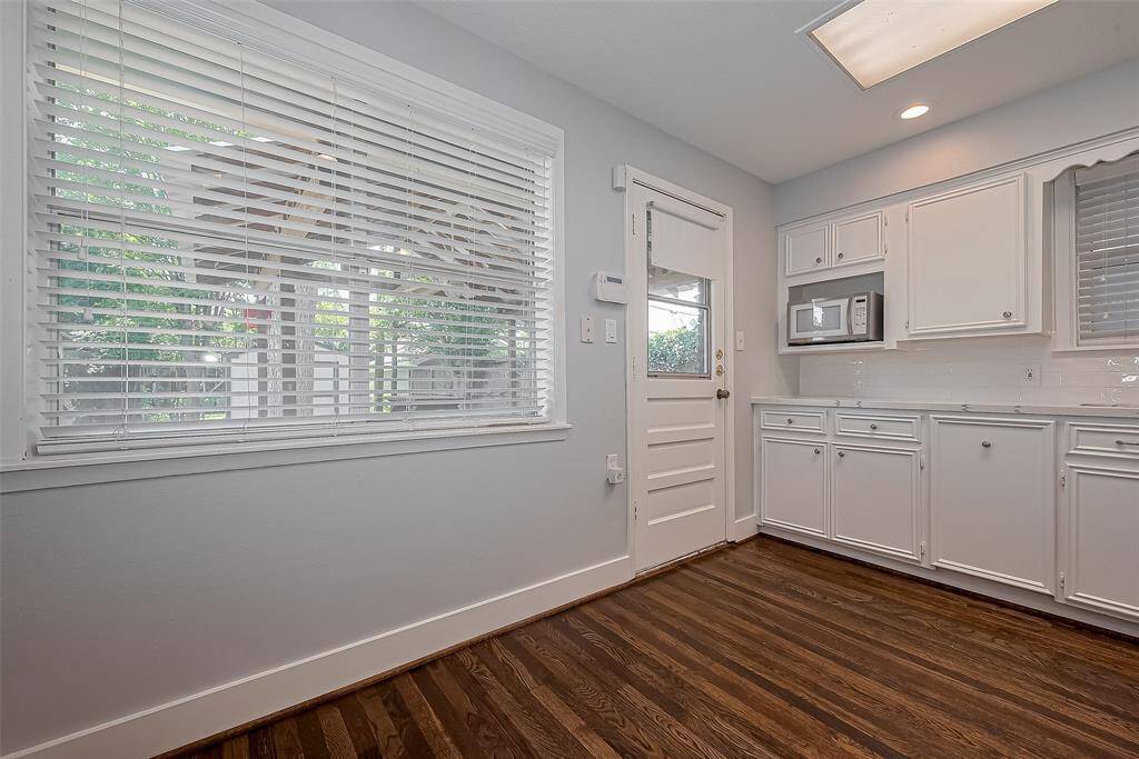This bathroom features a clean, modern design with light gray walls, white wainscoting, and a geometric tile floor. It includes a sleek white vanity, a mirrored medicine cabinet, and bright lighting, creating a fresh and inviting space.