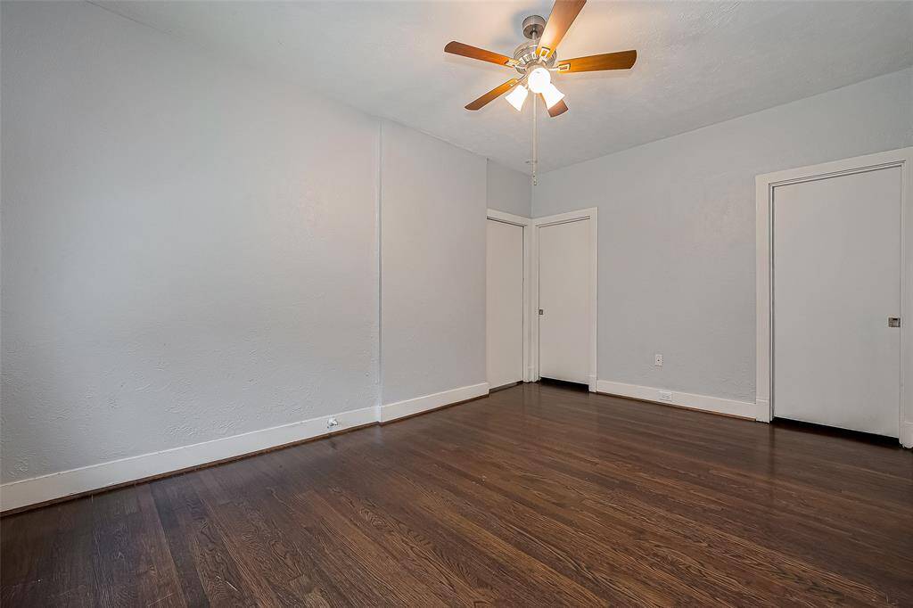 Bright, cozy room with hardwood floors, a window with blinds, and a white door leading outside. Clean, modern feel with neutral walls and recessed lighting. Ideal for a small office or mudroom.