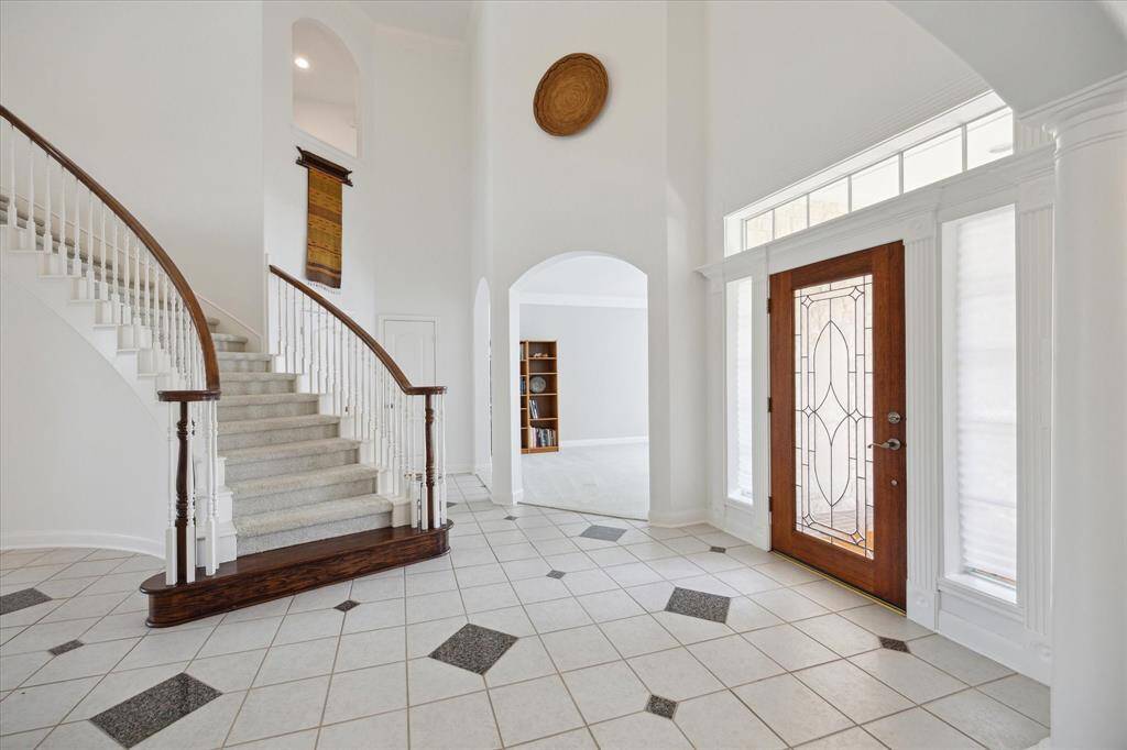 Custom granite inserts add a touch of character to the expansive foyer, enhancing the space while maintaining a light and bright atmosphere.