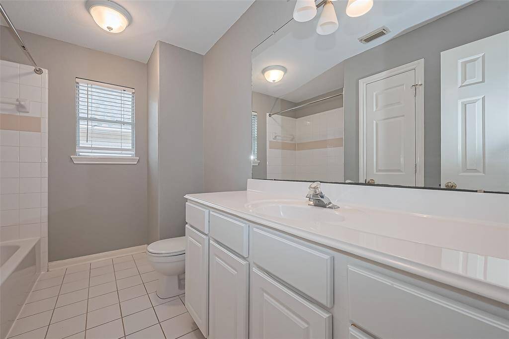 The upstairs bathroom  window includes a window for light and marble counters.