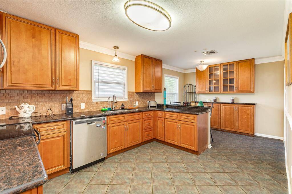 The kitchen has loads of cabinetry, stainless appliances, and granite counters.