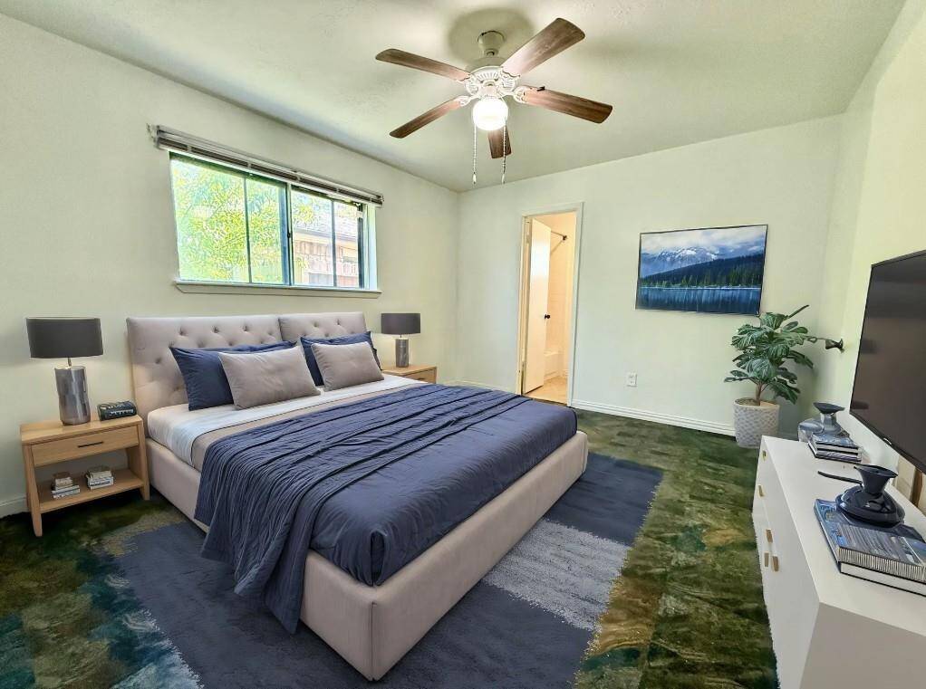 Luxurious primary bedroom featuring an en-suite bathroom, beautifully virtually staged for your inspiration.