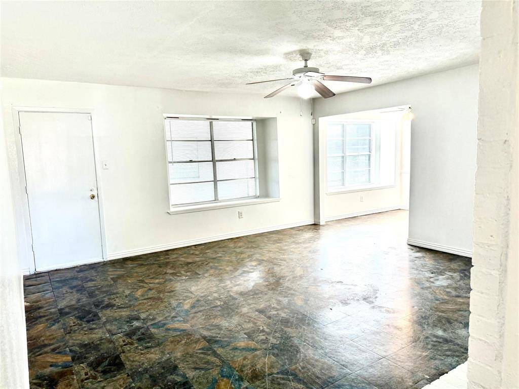 Expansive living room at the hallway's end, perfect for relaxation and entertaining.