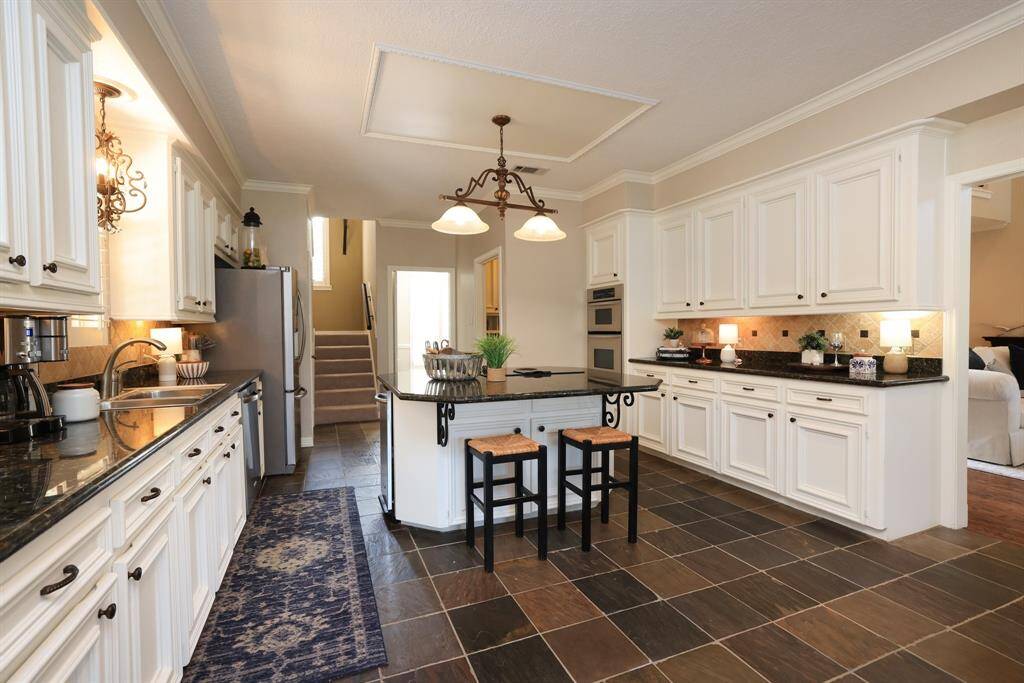 The sun room is just off the kitchen and features slate floors and 2-inch blinds.