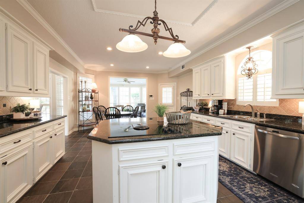 This view of the kitchen island shows a glass top electric stove. There is a gas connection underneath.