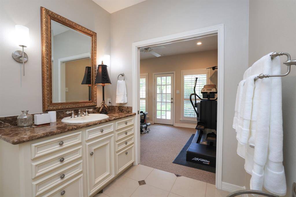 The primary bathroom includes two elegant emperador marble vanities and marble floors.