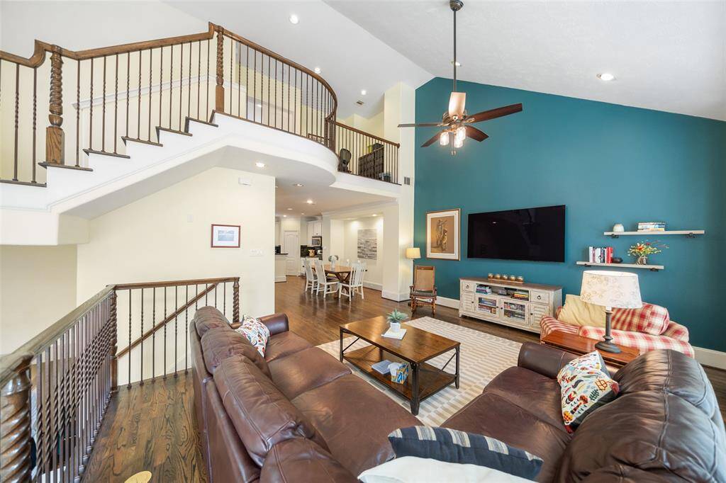 This view of the living room highlights the upstairs loft and high ceilings, creating an open and airy feel throughout the space.