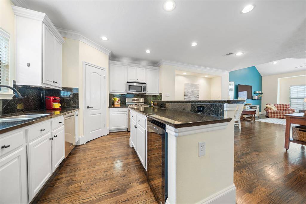 A wine cooler/beverage fridge is tucked neatly under the countertop in the island