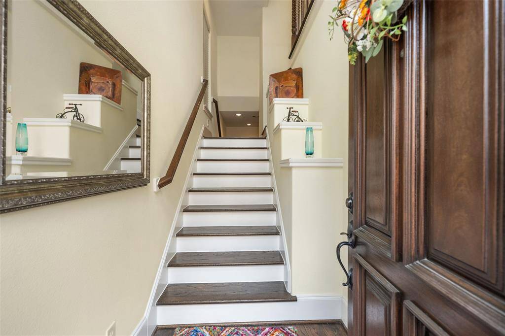 As you enter, a flight of stairs leads you either up to the main living area or down to the additional secondary bedrooms, offering convenient access to both levels of the home.