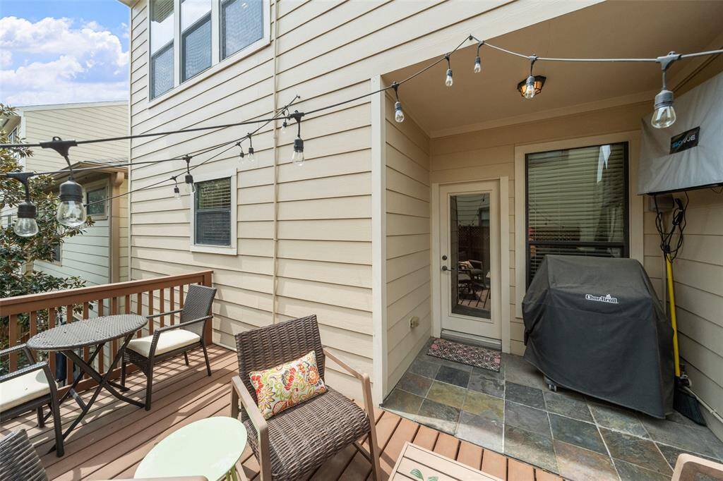 This viewpoint highlights the original balcony which is now being used for a grill and a hanging outdoor TV, adding to the deck's appeal for outdoor cooking and entertainment