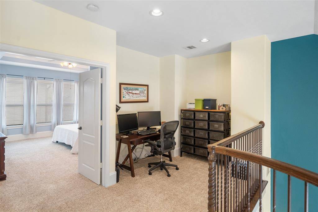 The loft or office area, located just outside the primary bedroom on the third floor, offers a versatile space that can be used for work or relaxation.