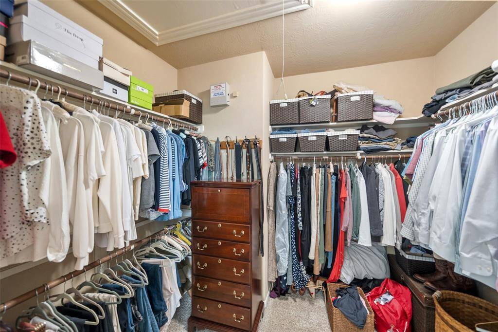 The spacious primary closet offers plenty of storage options, providing ample space for your entire wardrobe.