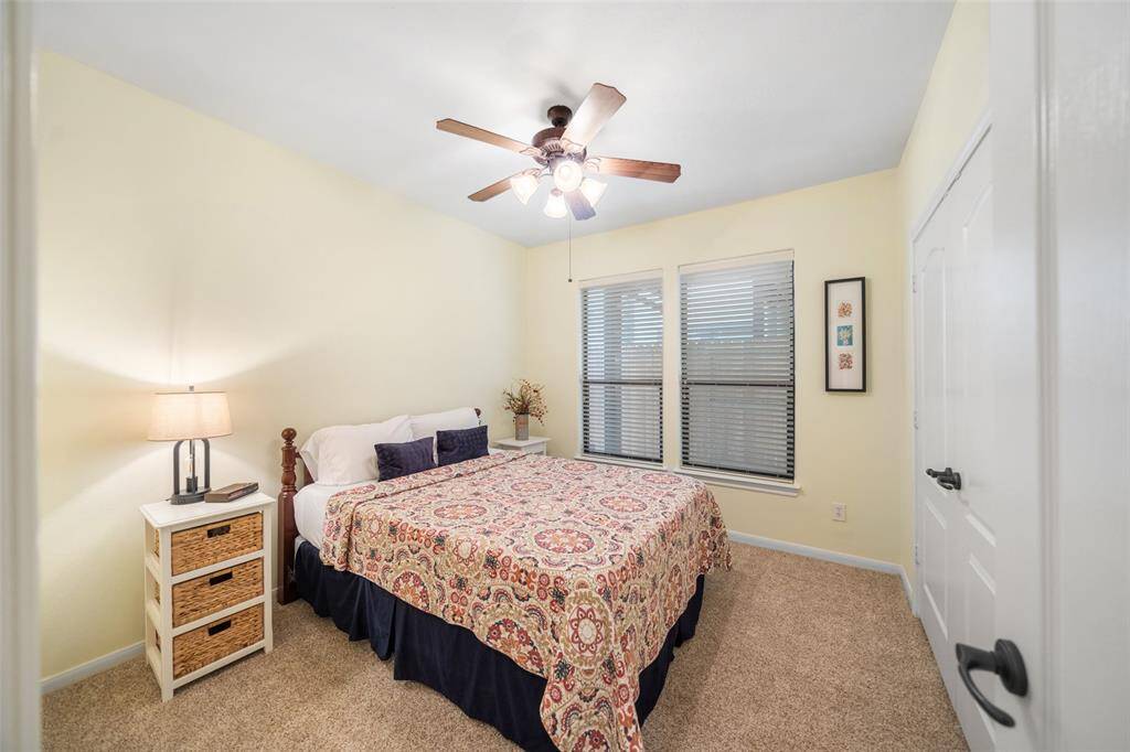 One of two secondary bedrooms on the first floor, featuring plush carpet and a double-door closet for plenty of storage. This room is also shaded by the second-floor deck, adding to its quiet, comfortable feel.
