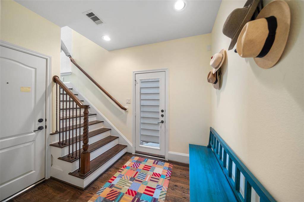 This photo shows the first-floor landing, providing access to the garage and a door leading out to the gravel backyard