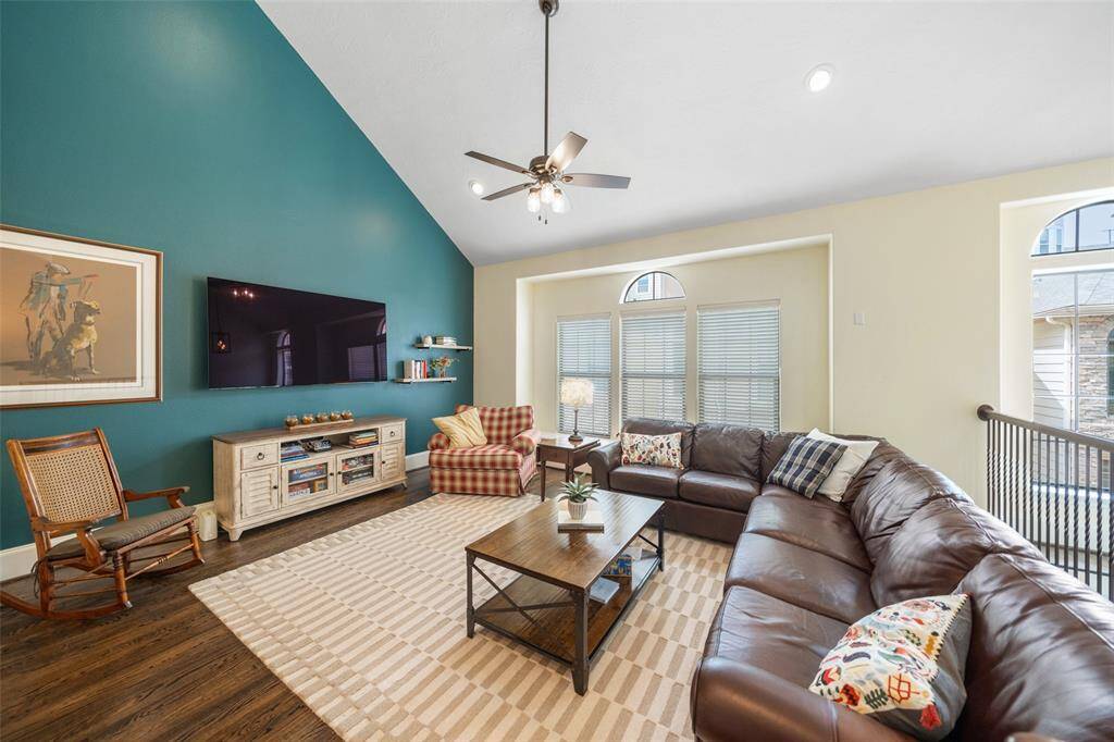 The spacious living room features beautiful hardwood floors and a vaulted ceiling, offering ample room for all your needs