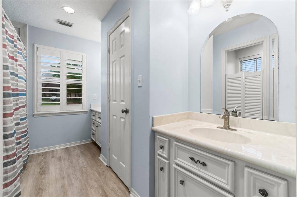Primary bathroom with double vanities and large walk in closet.