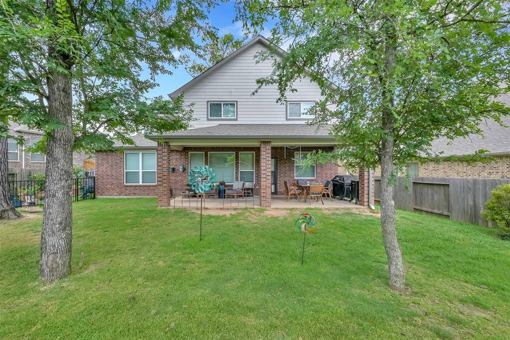 Backyard features a lush lawn, and the perfect of number of trees to create some shade on those hot summer days.