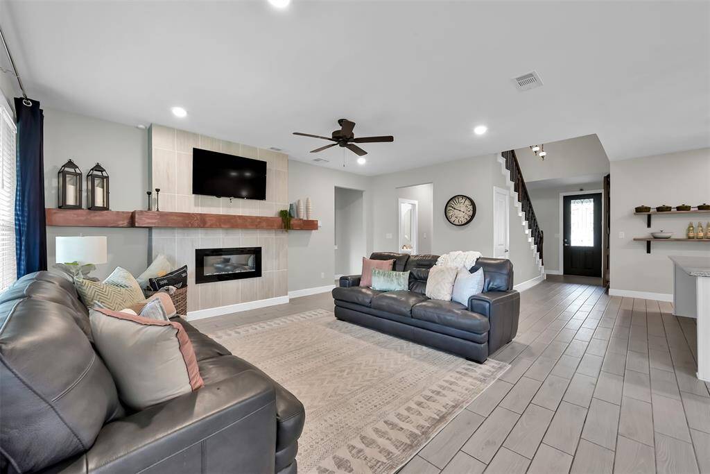 Elegant wood-look tile floors and premium finishes enhance this spacious, versatile room.