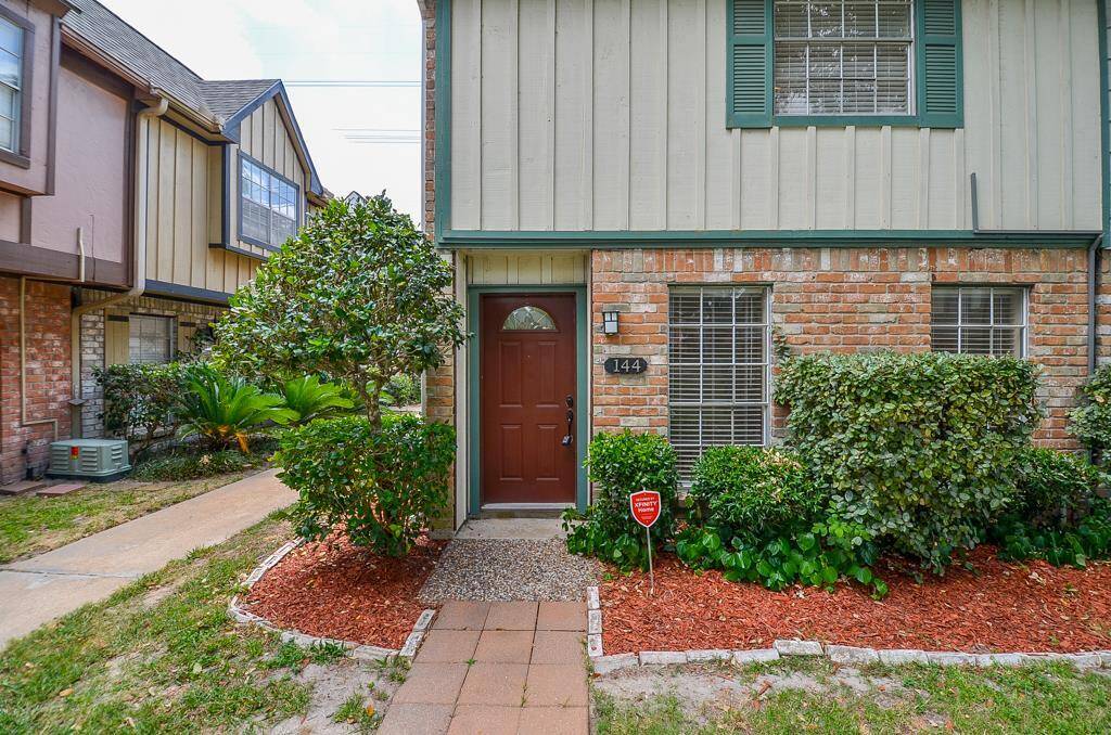 Charming townhouse exterior featuring a blend of brick and siding, complemented by well-maintained landscaping. The inviting front door is framed by shrubs, adding a touch of greenery. Ideal for buyers seeking a cozy, low-maintenance home.