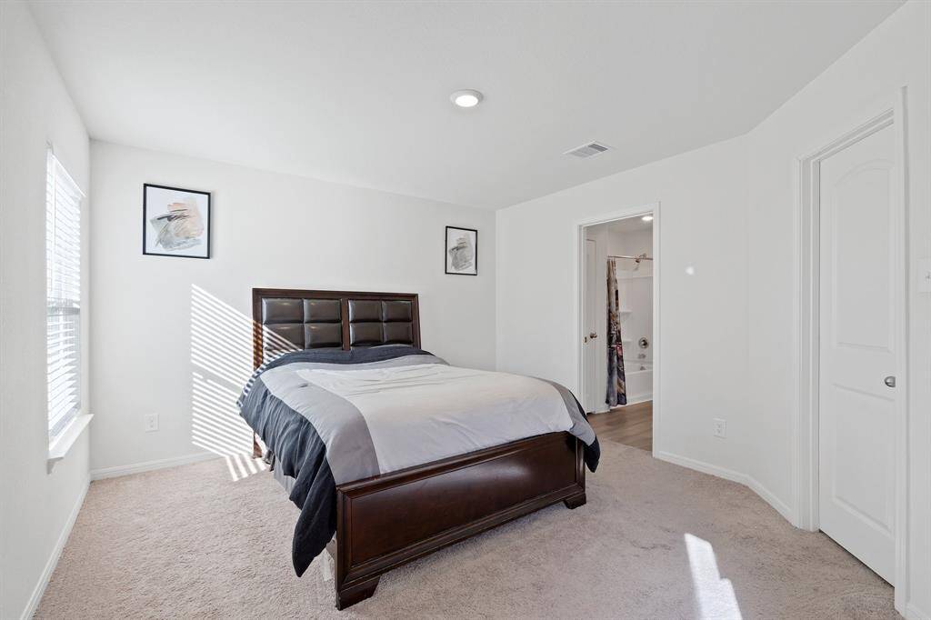 The primary bedroom is generously sized, creating a tranquil and spacious retreat that offers ample room for relaxation. Featuring plush carpet, high ceilings, fresh paint, and large windows that lets in natural lighting throughout the day.