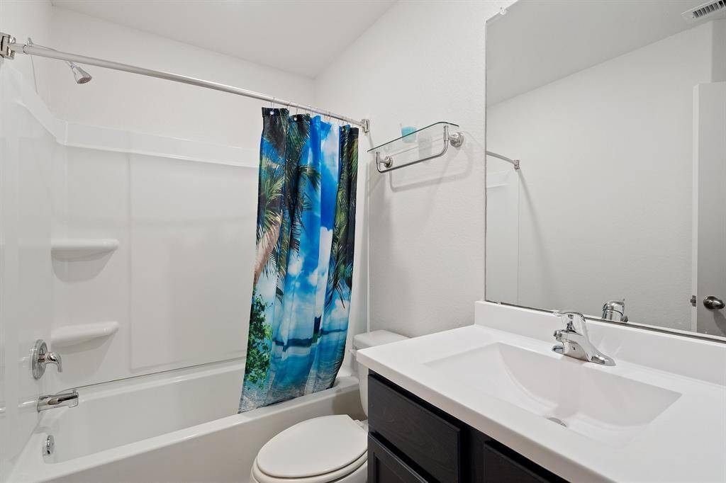 The secondary bath features tile flooring, white cabinetry and light countertops and a shower/tub combo. Perfect for accommodating any visiting family and friends.