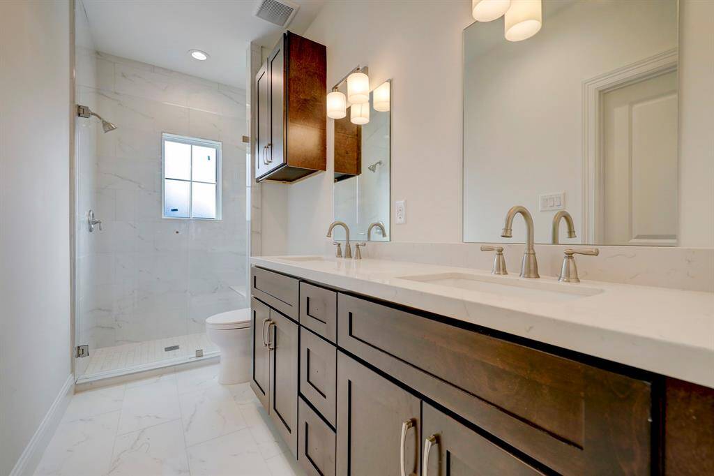 Primary bathroom features quartz countertops, dual sinks, a standalone shower, and plenty of cabinet space for all your essentials.