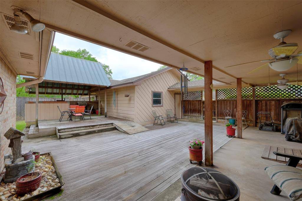 Covered walkway from the garage to the home with fence for privacy. The porch and deck space are large enough for several seating areas.