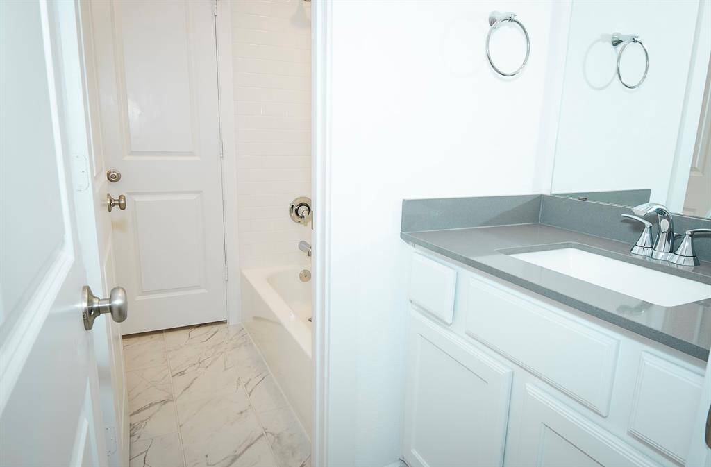 This stylish Jack and Jill bathroom features modern fixtures, elegant tile flooring, and a sleek vanity, offering both functionality and charm. Perfect for shared convenience.