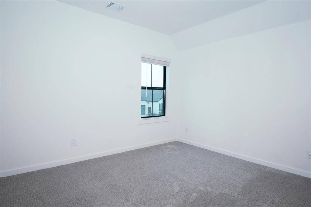 Bright and inviting upstairs bedroom with plenty of natural light, offering a cozy retreat.