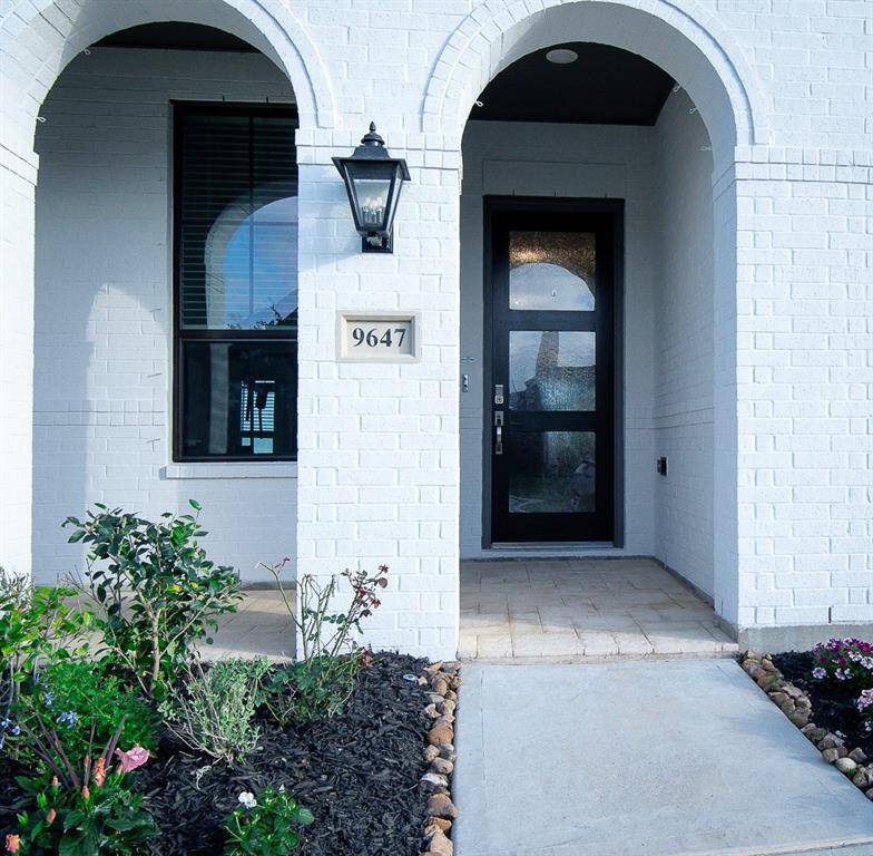 Welcoming entrance with elegant arches and charming landscaping.
