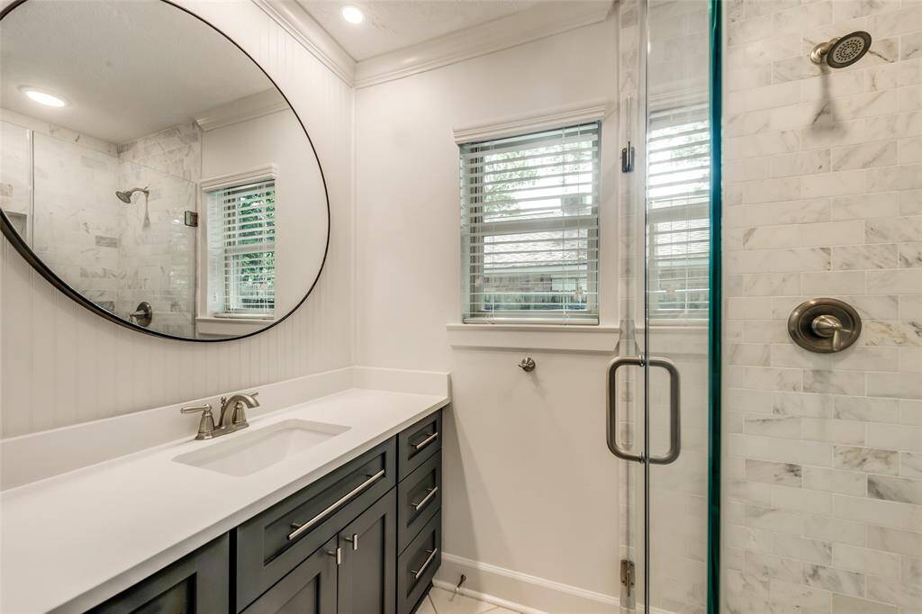 More upgrades in the main bathroom, including accent walls, new shower, vanity, and mirror.