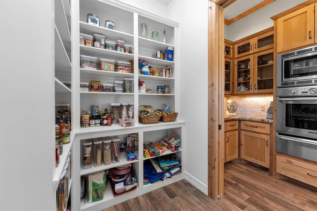 This massive walk-in pantry, paired with a spacious butler’s pantry, is sure to please the family chef—offering ample room for food storage, small appliances, and meal prep essentials. Don’t miss the built-in oven, microwave, and convenient warming drawer that make cooking and entertaining a breeze.