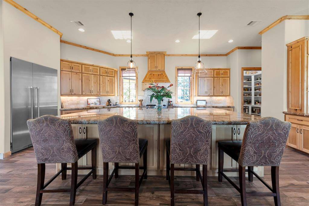 Gather around the oversized island with comfortable bar seating in this open-concept kitchen, designed with high-end finishes and thoughtful details throughout. There’s plenty of room for the family chef, a sous chef, and the cleanup crew, all while staying connected to the action in the surrounding living and dining spaces.