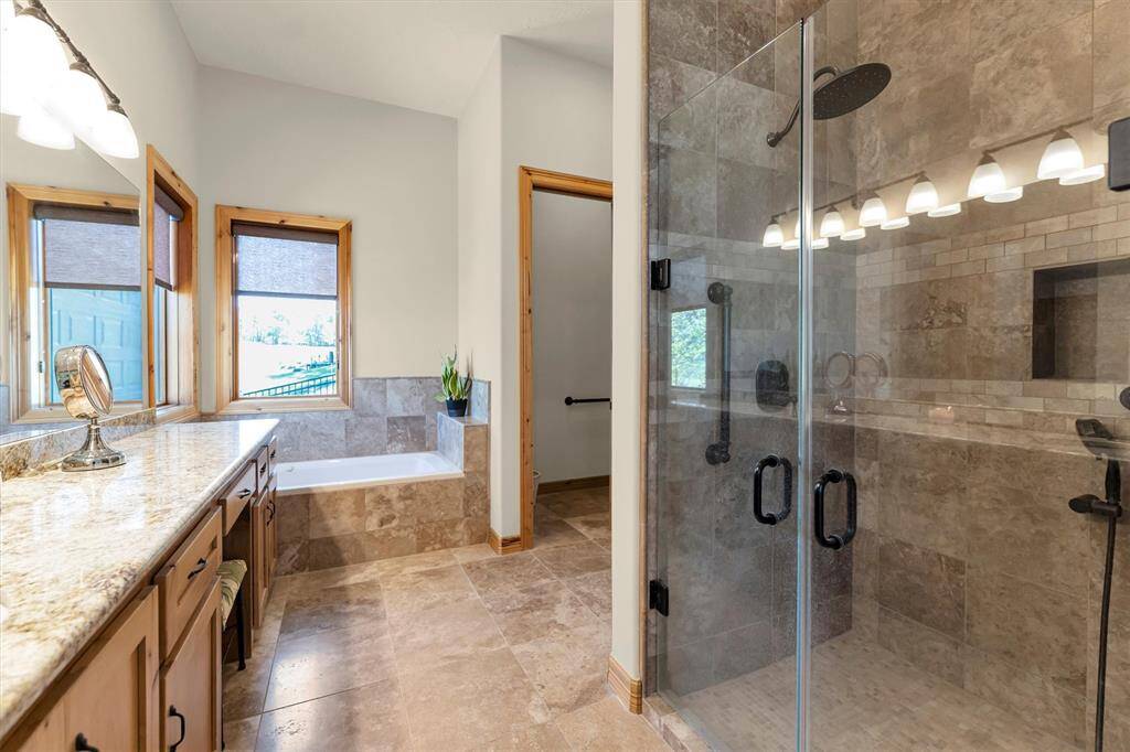 Relax and soak your worries away in this luxurious jetted tub or enjoy a quick rinse in the spacious walk-in shower with frameless glass, upgraded fixtures, and dual shower heads. Either way, you'll love this private retreat.