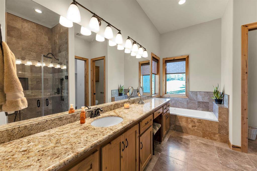 Luxurious guest accommodations continue into this beautifully designed ensuite, featuring an expansive granite-topped vanity, a soothing jetted tub, and an oversized walk-in shower with frameless glass and dual shower heads—offering a spa-like experience your guests will love.