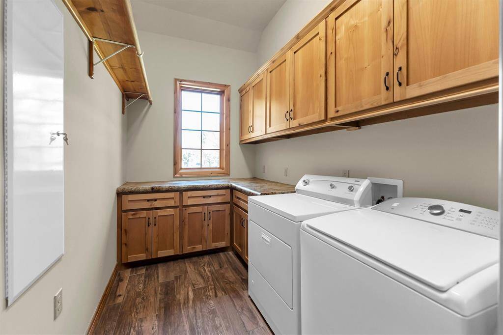 Laundry is a breeze in this well-equipped utility room, featuring ample storage and a convenient folding counter. Ideally located near the mud room, it offers both function and efficiency to keep daily tasks running smoothly.