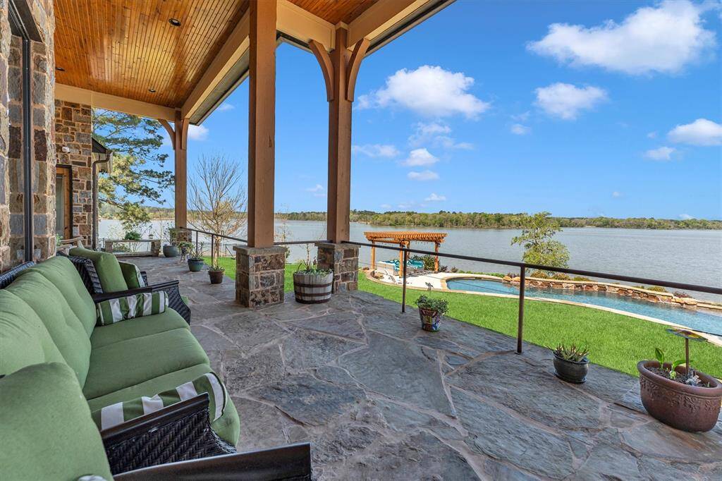 Relax and soak up the breathtaking views of Waterwood bay from this covered stone patio, perfectly situated to overlook the sparkling pool and lake. With a soaring wood-paneled ceiling and ample pace for seating, it’s the perfect setting for morning coffee, afternoon lounging, or enjoying a golden sunset by the water.
