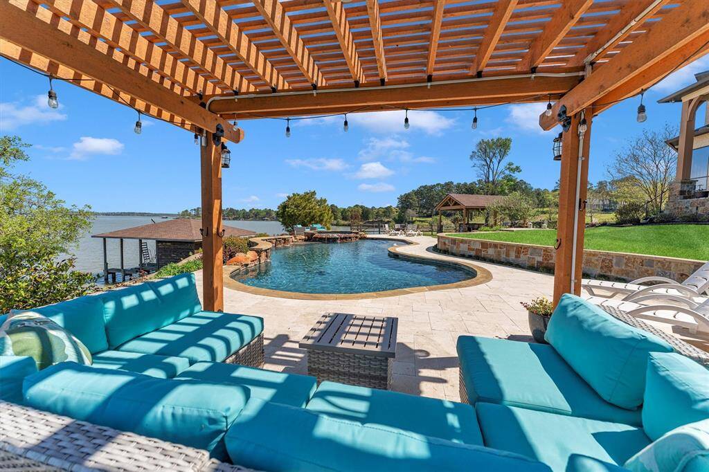 Take a dip—the water is perfect! This outdoor retreat offers multiple seating areas to soak in the stunning lake views, including a pergola-covered patio right by the pool. A nearby summer kitchen makes entertaining a breeze, creating the ultimate setting for relaxed lakeside living.