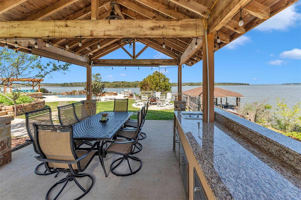 Nestled poolside and overlooking Waterwood bay, this covered summer kitchen boasts sleek granite countertops and stainless steel appliances—perfect for preparing today’s fresh catch. Savor your meal as the sun sets over the water, wrapping up another perfect day of lakeside living.