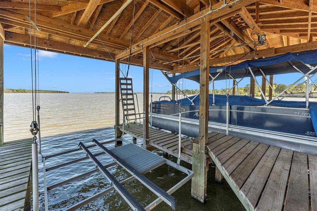 This fully loaded boathouse is ready for all your lake adventures, featuring a convenient fish cleaning station, dedicated gear storage, one tri-toon lift, one V-hull lift, and a double jet ski lift—everything you need for a full day of fun on the water.