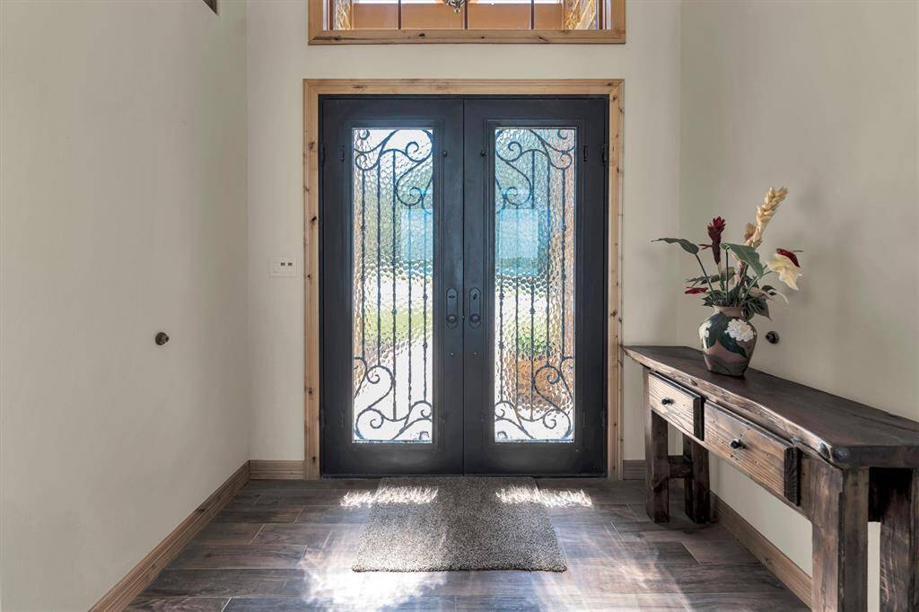 Elegant leaded glass doors set the tone for high-end finishes and inviting design that flows effortlessly from the front door to the water’s edge.
