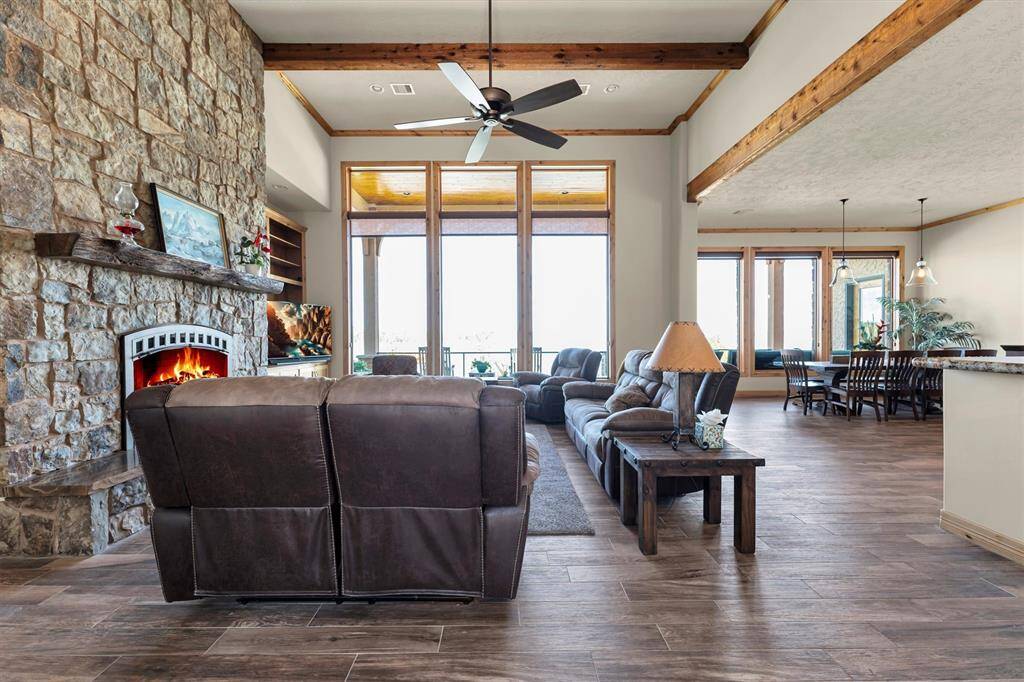 This gorgeous family room offers picture-perfect views of the patio, sparkling pool, and open water. A stunning stone fireplace anchors the space, flanked by custom built-in shelving to showcase your favorite pieces. Open to the dining area, island kitchen, and nearby game room, it's the ideal hub for everyday living and entertaining.