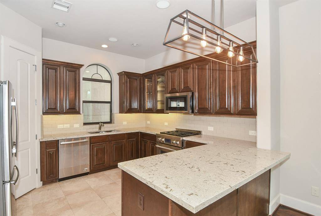 The fully upgraded kitchen features premium Jenn Air Pro appliances, and for added convenience, the fridge is included with the lease.